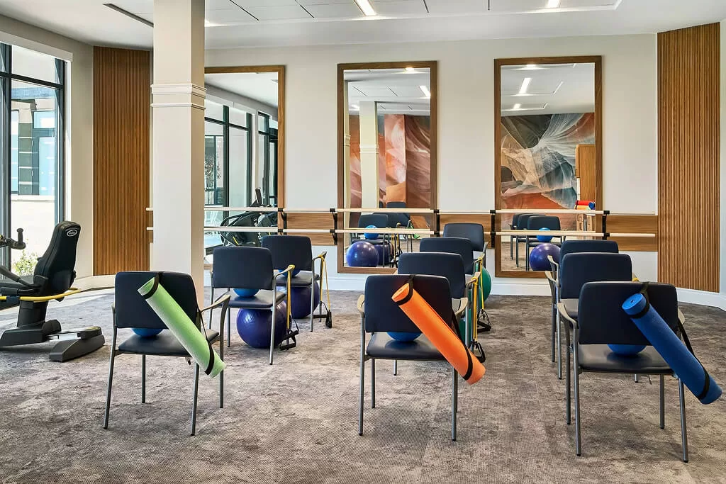 Senior living fitness room with adaptive equipment and mirrored walls