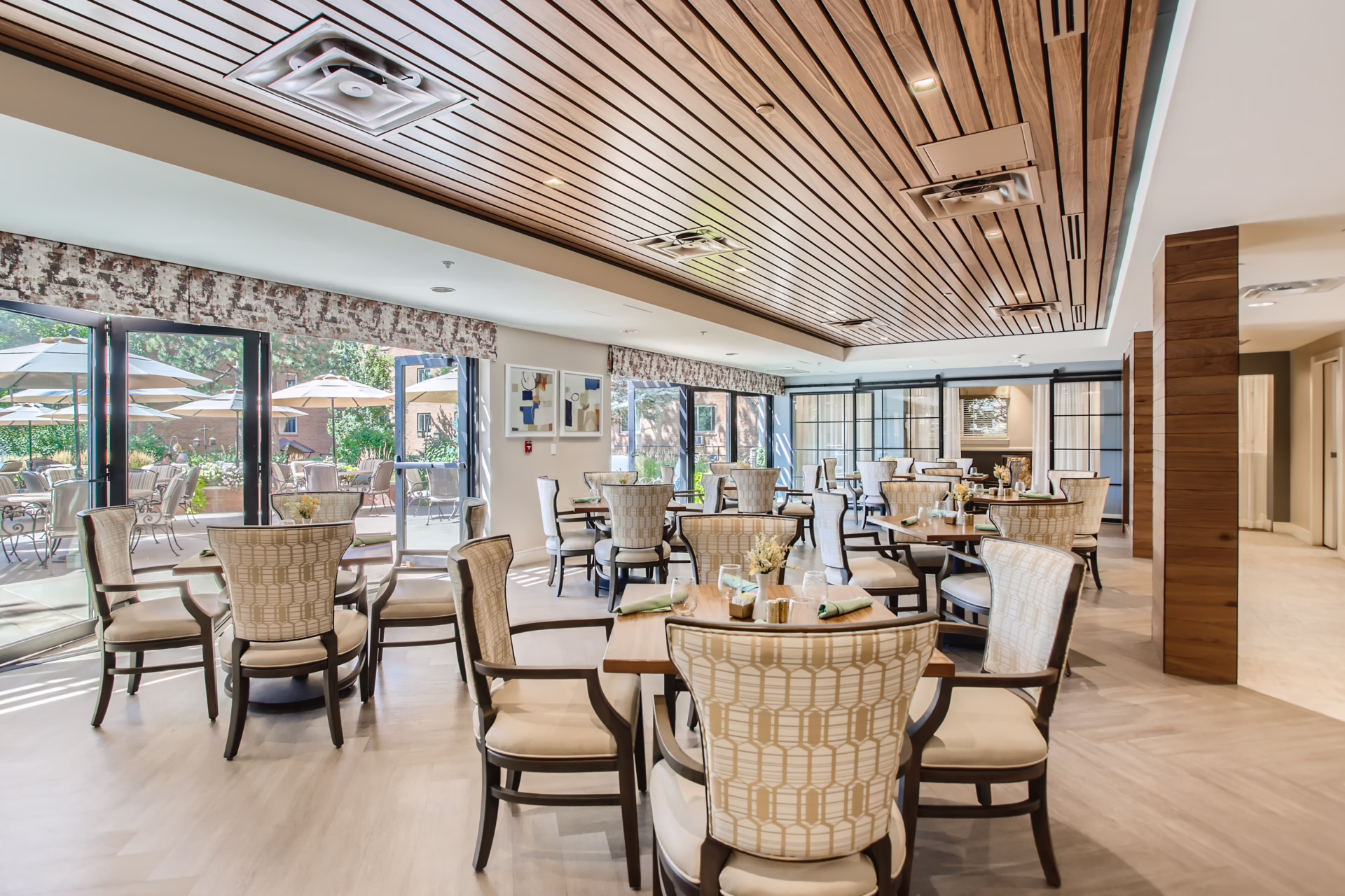 Senior living community kitchen with natural materials and warm finishes by Aneka Interiors